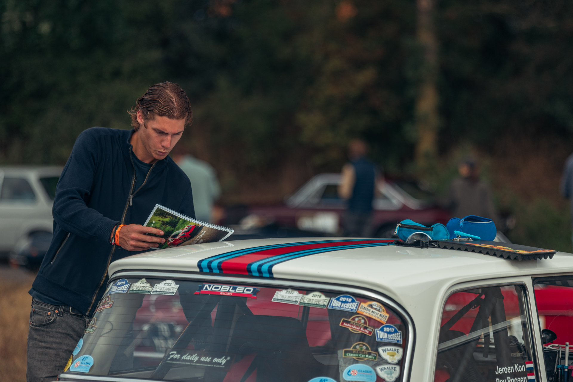Navigator leest het routeboek op het dak van een Mini